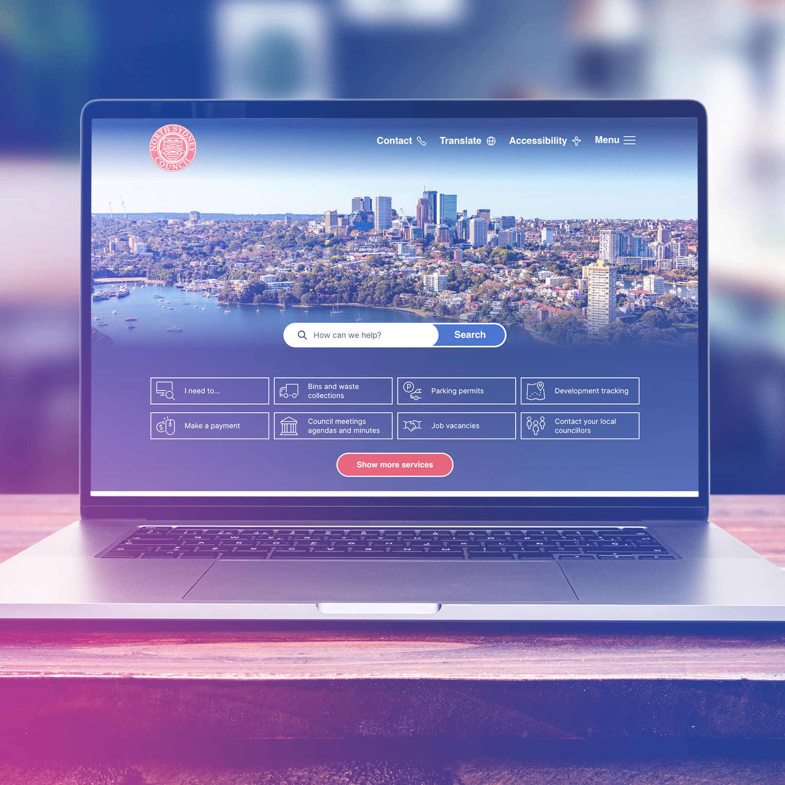 Colourful laptop on a desk displaying the North Sydney website.